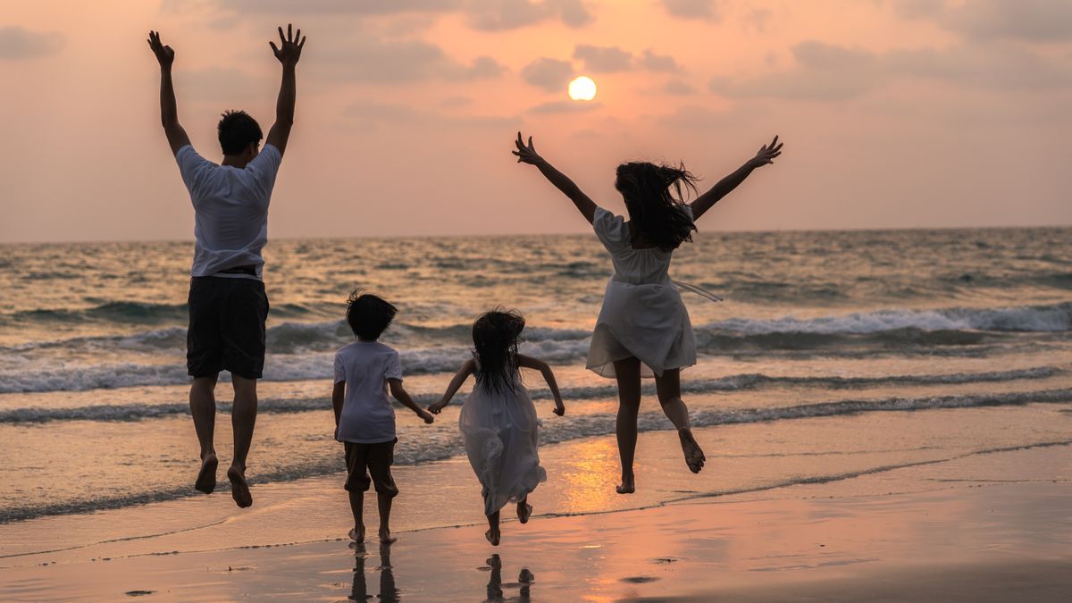 Una familia disfrutando del atardecer en la playa.