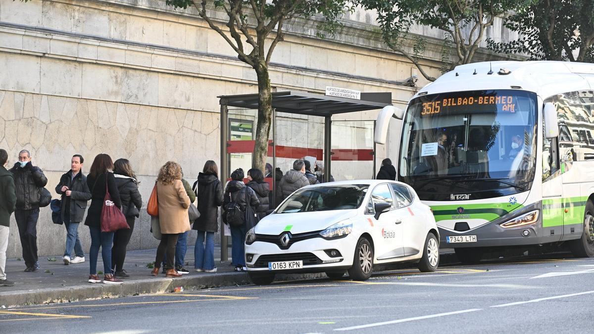 Viajeros esperan al autobús en una de las paradas de Bizkaibus