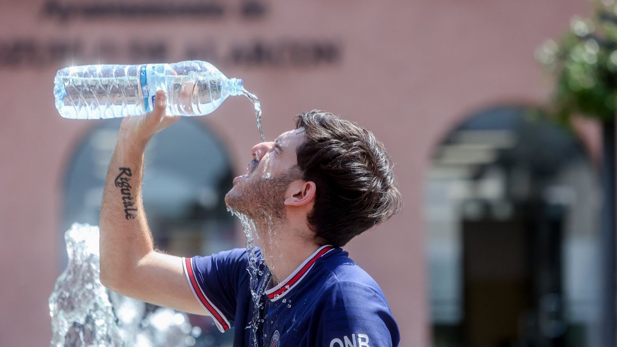 Un joven se echa agua para combatir el calor