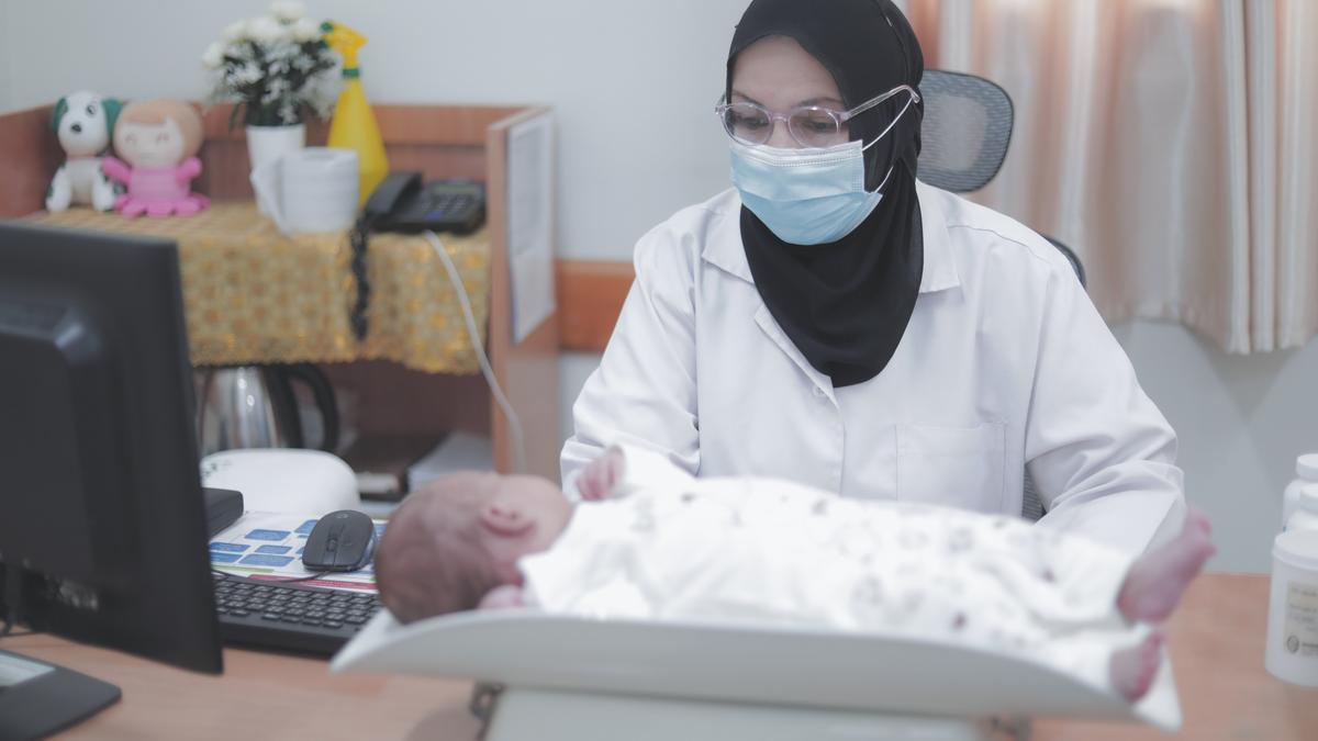 Una médica palestina atiende a un bebé.