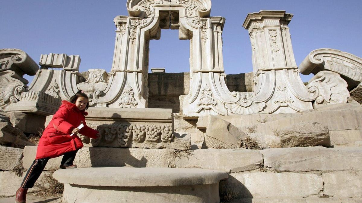 Un visitante camina por las ruinas del Palacio Antiguo de verano, antiguos jardines imperiales de la dinastía Qing