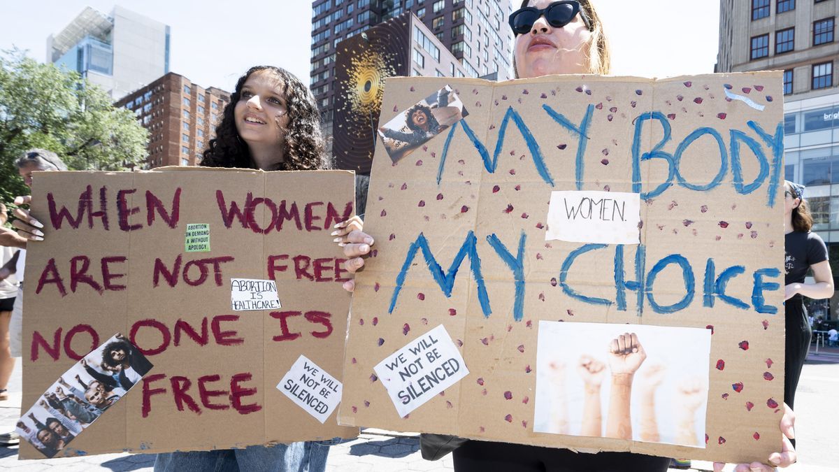 Dos mujeres sostienen pancartas durante una manifestación por el derecho al aborto.