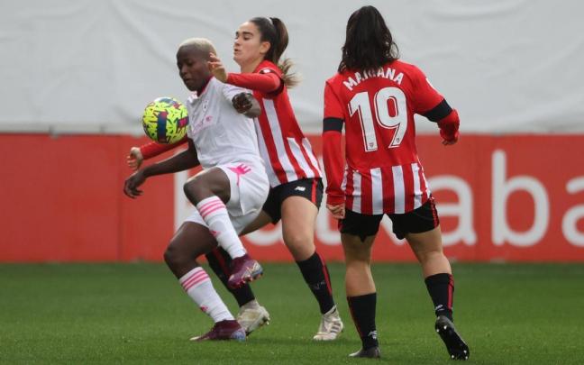 Mariana observa cómo su compañera trata de recuperar un balón.