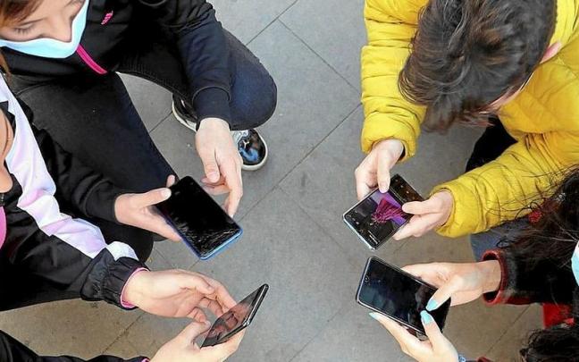 Un grupo de jóvenes usan el teléfono móvil. | FOTO: E.P.