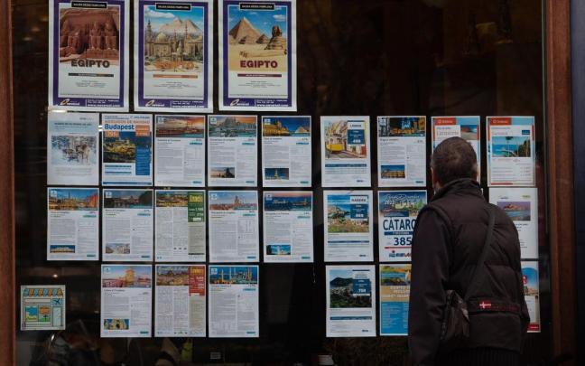 Un ciudadano observa el escaparate de una agencia de viajes, con ofertas para el puente foral. Un ciudadano observa el escaparate de una agencia de viajes, con ofertas para el puente foral.