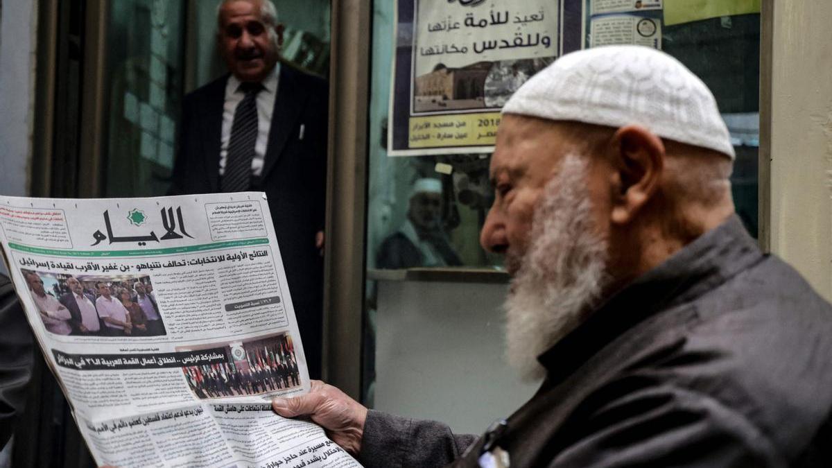 Un hombre lee en un periódico la noticia de la victoria de Netanyahu en las elecciones.