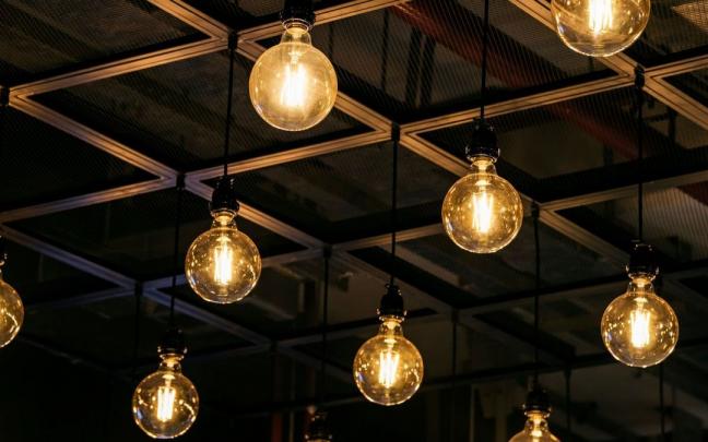 Bombillas de luz amarilla cuelgan de un techo.