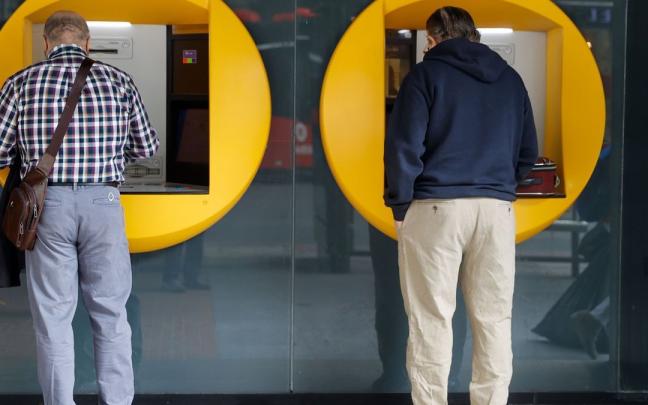 Dos hombres sacan dinero en un cajero automático. Dos hombres sacan dinero en un cajero automático.