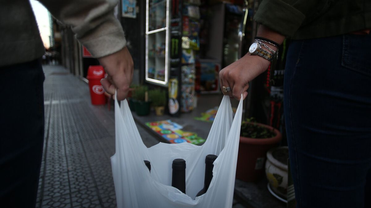 Jóvenes portando una bolsa llena de alcohol.