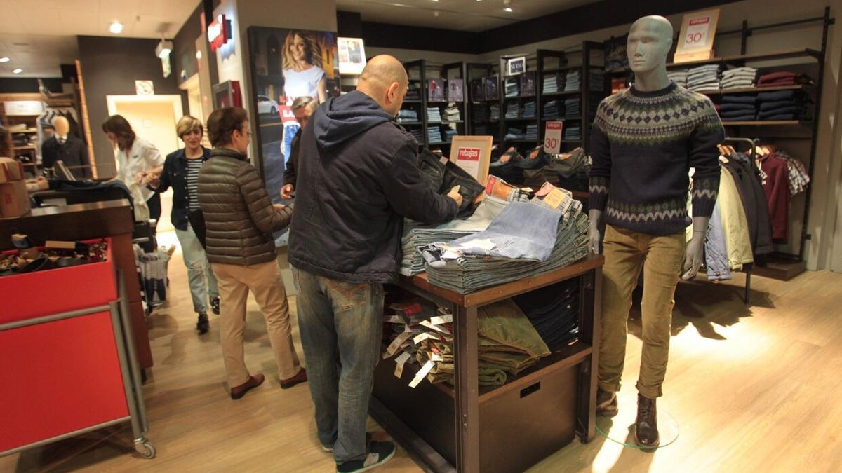 Clientes mirando ropa en el primer día de rebajas de invierno.