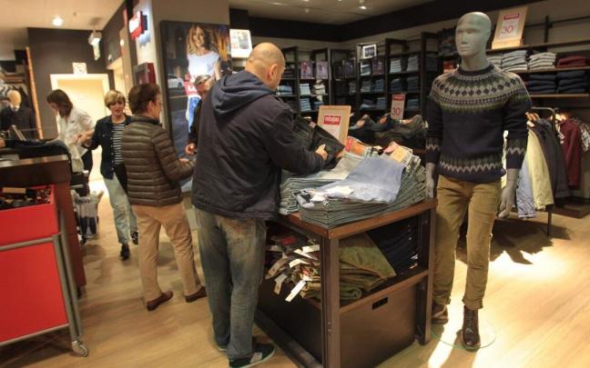 Clientes mirando ropa en el primer día de rebajas de invierno. Clientes mirando ropa en el primer día de rebajas de invierno.