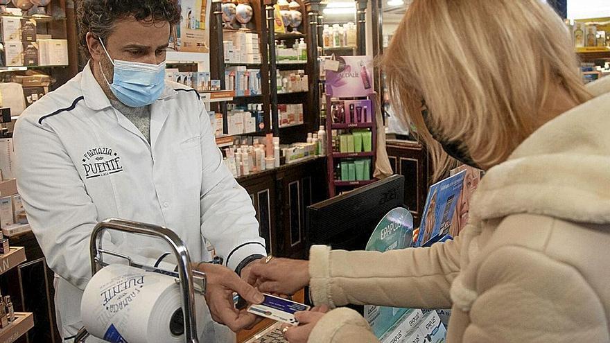 Una mujer adquiere fármacos, ayer, en la farmacia Puente.