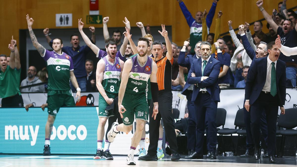 Los jugadores de Unicaja celebran en el banquillo, junto a Ibon Navarro, una canasta en el partido ante el Real Madrid