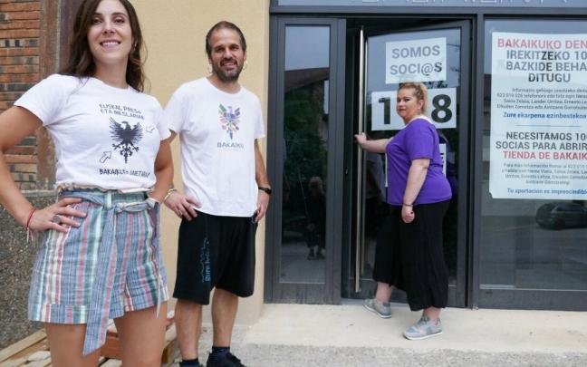 Nerea Viana, Lander Urritza y Saioa Zelaia, miembros del grupo motor de Bakaikuarrok, en el exterior de la tienda.