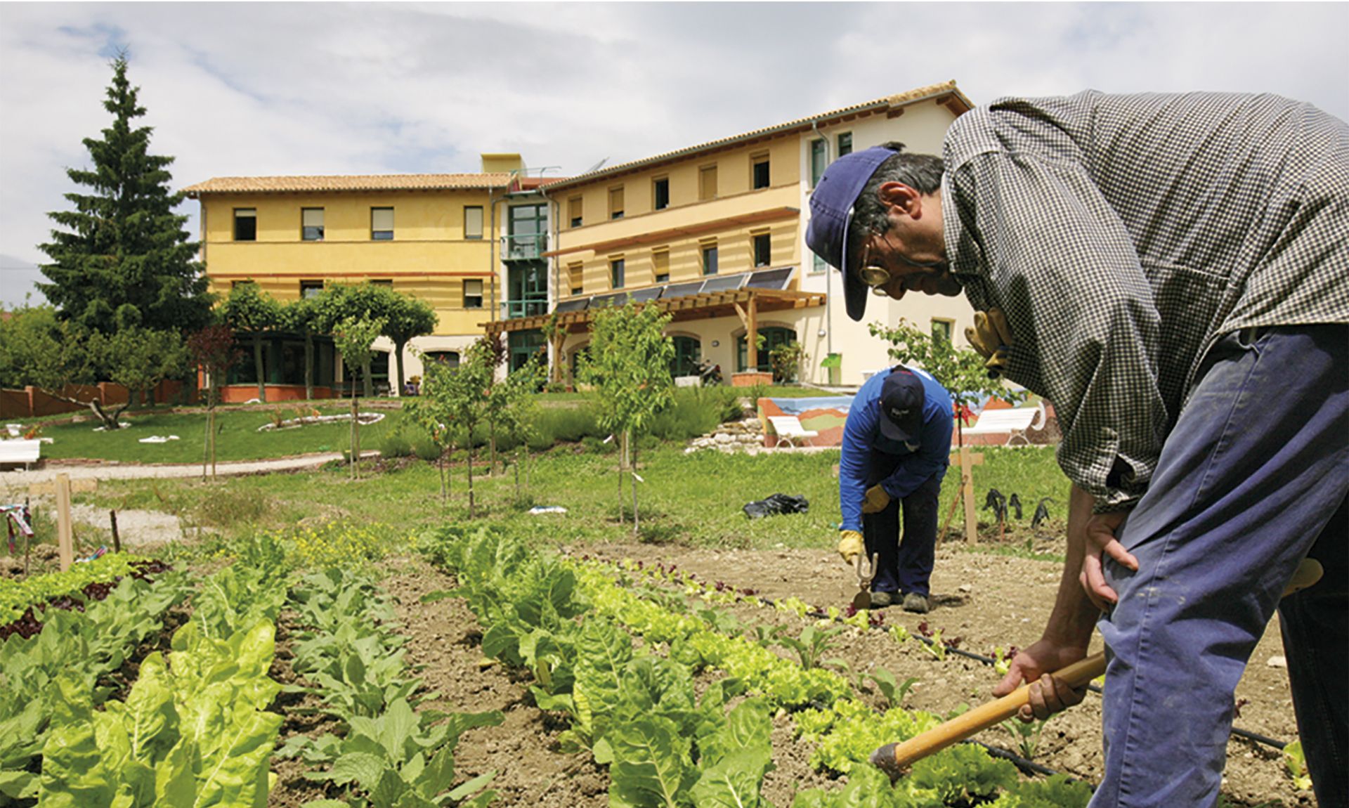 Dos residentes trabajan la huerta en la Comunidad de Traperos en Belzunce.