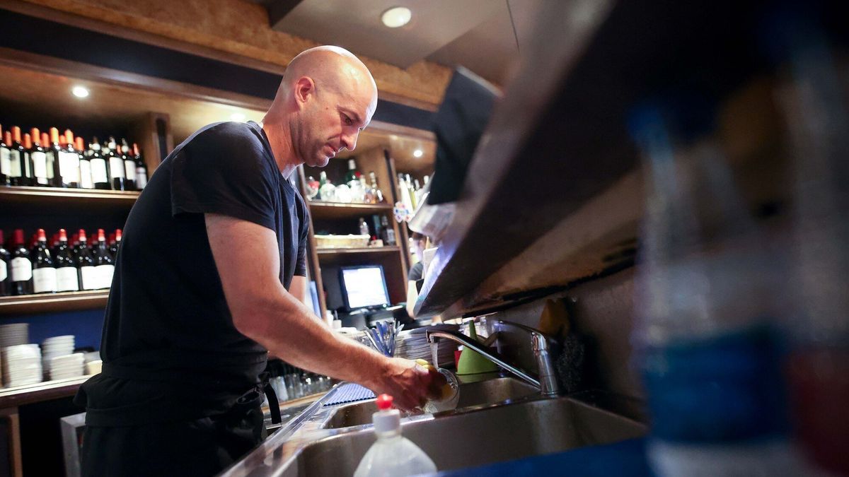 Un camarero lava un vaso en el Izaro Irish Pub de Bermeo