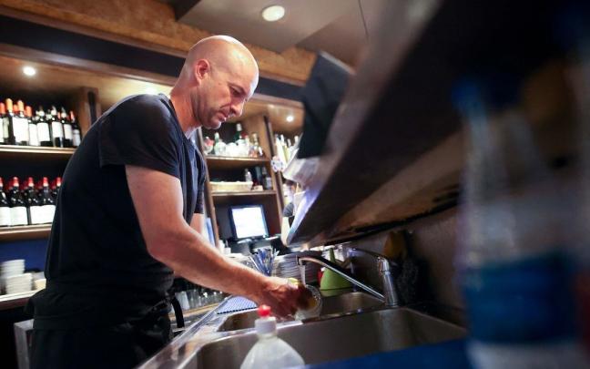 Un camarero lava un vaso en el Izaro Irish Pub de Bermeo Un camarero lava un vaso en el Izaro Irish Pub de Bermeo