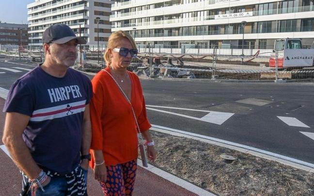Una pareja pasea frente a un edificio en construcci&oacute;n.