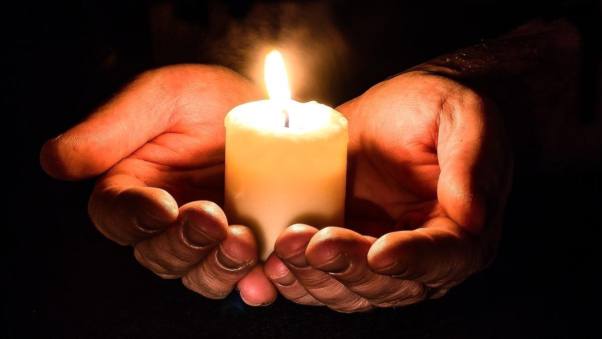 Una persona sostiene una vela entre las manos