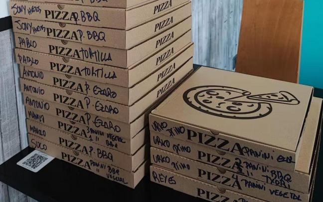 Cajas de pizzas caseras y paninis listas para entregar en la Mercedes
