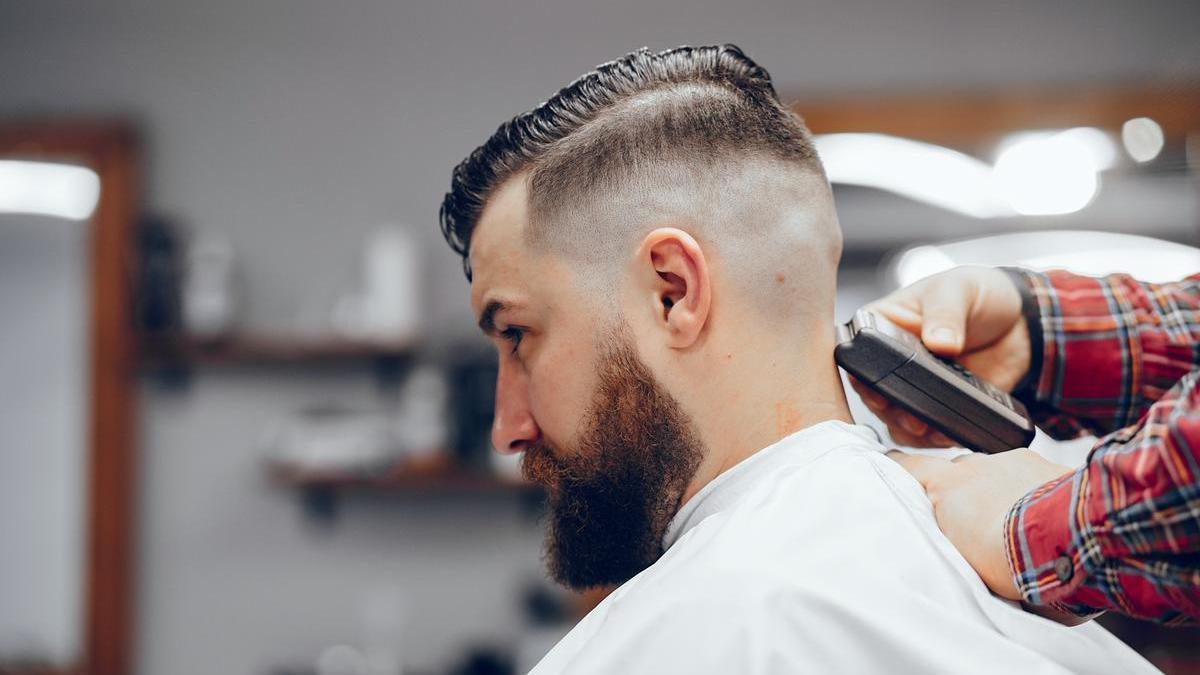 Un hombre se corta el pelo en una peluquería.