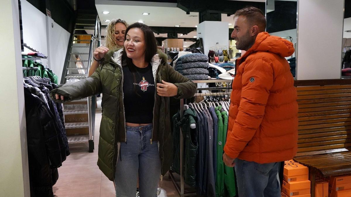 Varios turistas se prueban ropa de abrigo en la tienda Olañeta del Casco Viejo de Bilbao.