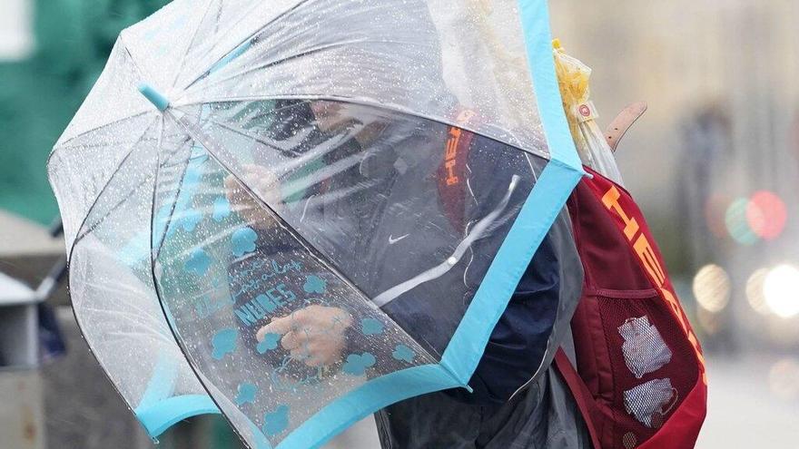 Una persona se protege de la lluvia con un paraguas