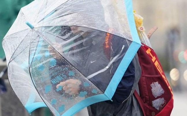 Una persona se protege de la lluvia con un paraguas