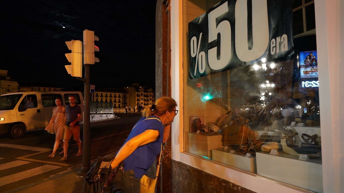 Una turista de Alicante mira en una zapatería con las luces apagadas