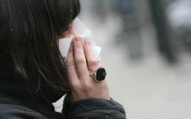 Imagen de archivo de una mujer limpi&aacute;ndose la nariz.