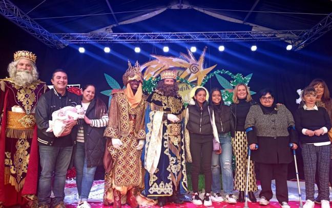 Fotografía de los Reyes Magos, representantes municipales y de Codisfiba, junto a Junari Gabriela y su familia.