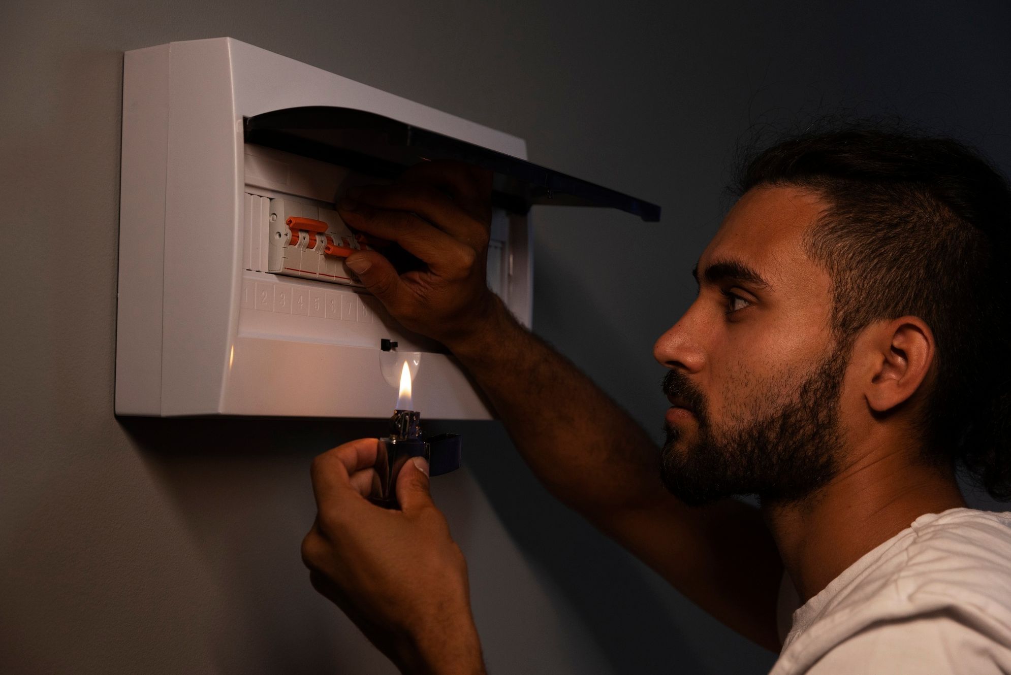 Un hombre manipula el cuadro eléctrico de una vivienda.