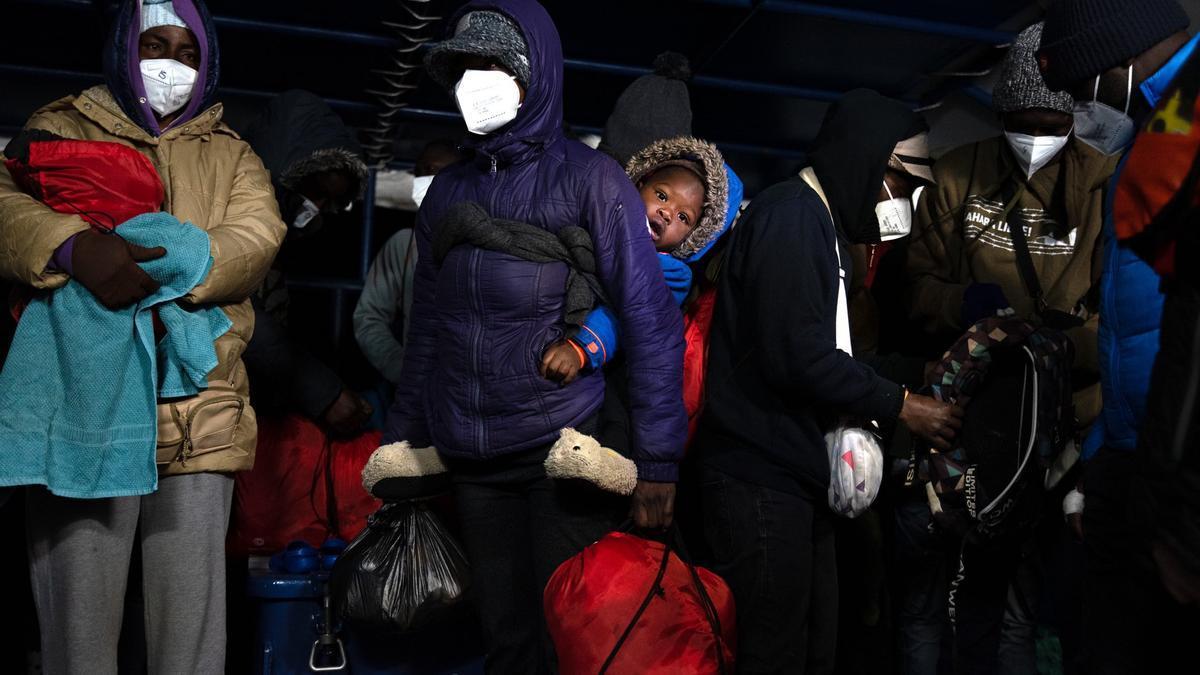 La treintena de náufragos rescatados por el 'Aita Mari', entre ellos una mujer con un bebé, durante el desembarco de este sábado en el puerto italino de Civitavecchia.