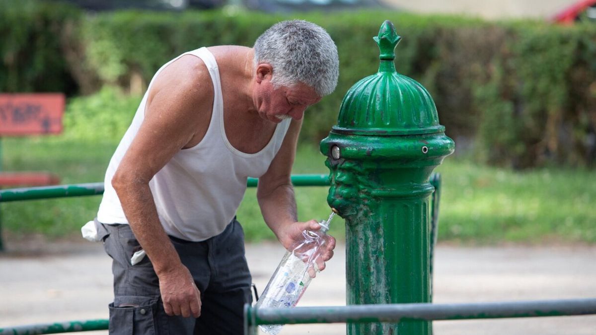 Un hombre llena una botella de agua en una de las fuentes de Pamplona