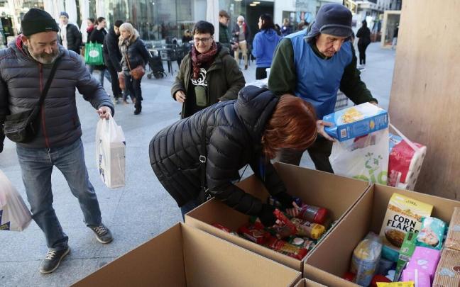 Varios voluntarios de Zaporeak ordenan en cajas la comida que está donando la gente en el puesto de La Bretxa. Varios voluntarios de Zaporeak ordenan en cajas la comida que está donando la gente en el puesto de La Bretxa.