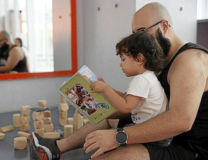 Un padre lee un cuenta con su hijo en Azpilagaña.