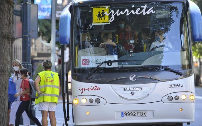Varios alumnos bajan del autobús escolar en el inicio del curso escolar.