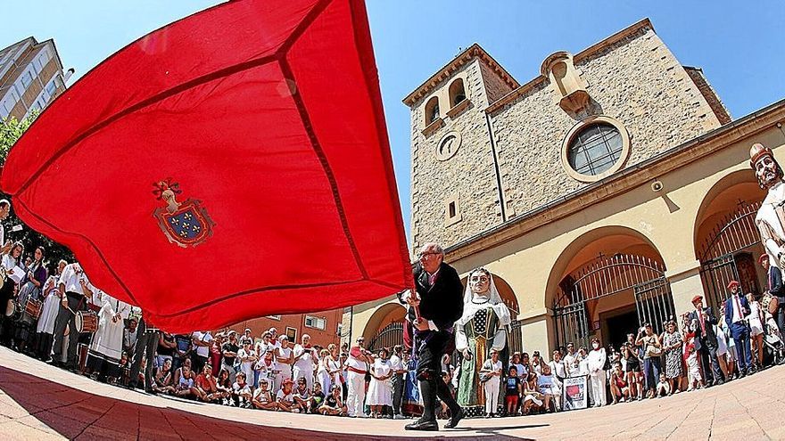 Miradas atentas ante la bandera de Burlada en la plaza de la Iglesia.