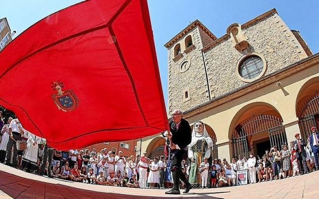 Miradas atentas ante la bandera de Burlada en la plaza de la Iglesia. Miradas atentas ante la bandera de Burlada en la plaza de la Iglesia.