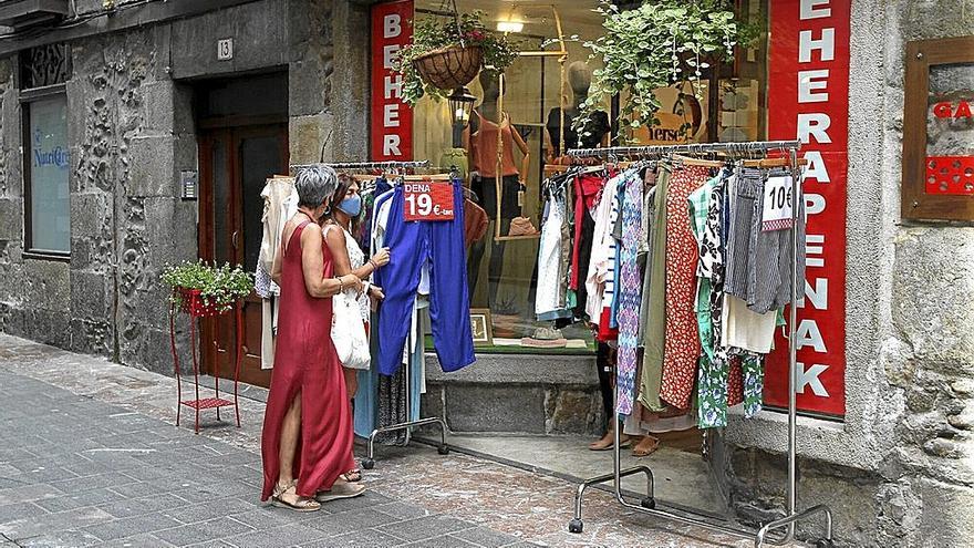 Dos personas en torno a un puesto de ropa habilitado en el exterior de un comercio de Elgoibar.