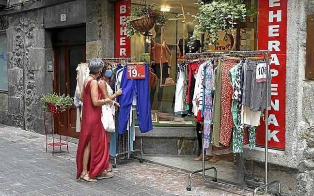 Dos personas en torno a un puesto de ropa habilitado en el exterior de un comercio de Elgoibar.