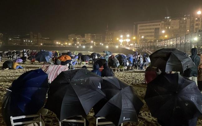 Decenas de personas se cobijan bajo paraguas esperando a los fuegos británicos que finalmente fueron suspendidos Decenas de personas se cobijan bajo paraguas esperando a los fuegos británicos que finalmente fueron suspendidos