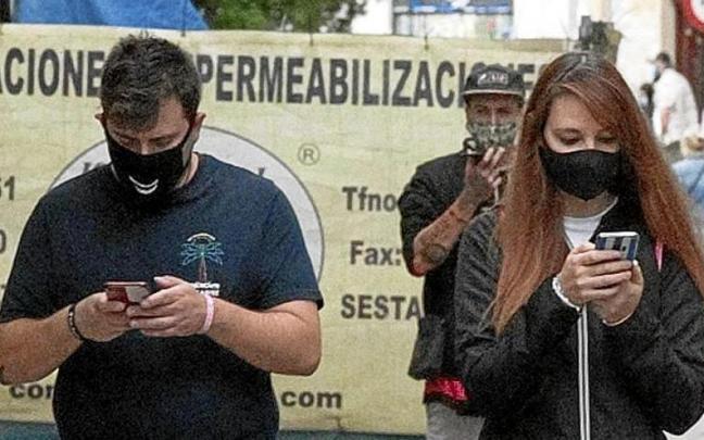 Telefono mugikorra erabiltzen duten gazte batzuk kaletik ibiltzen. | ARGAZKIA: JOSU CHAVARRI Telefono mugikorra erabiltzen duten gazte batzuk kaletik ibiltzen. | ARGAZKIA: JOSU CHAVARRI