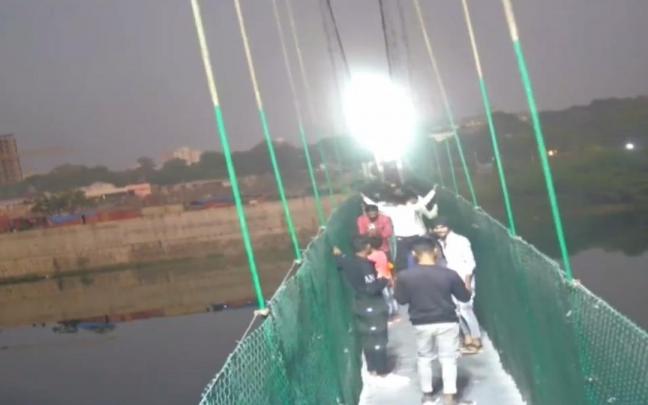 Los instantes anteriores al derrumbe del puente colgante en la India.