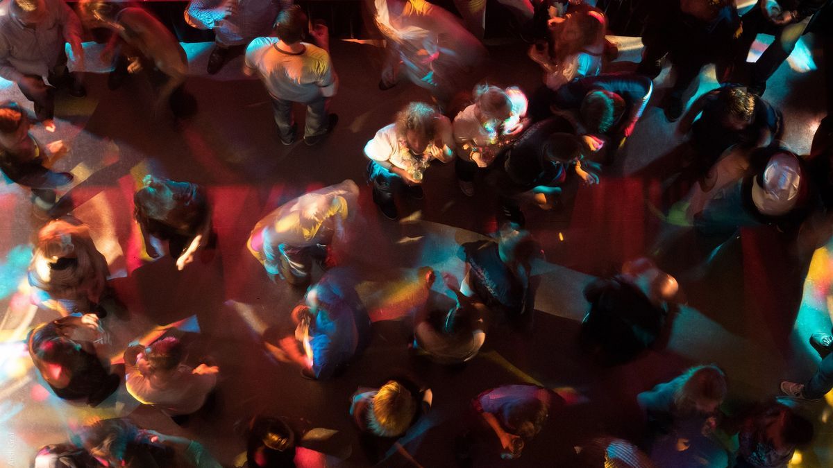 Un grupo de personas baila en una discoteca