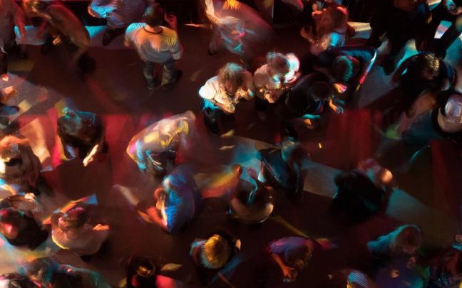 Un grupo de personas baila en una discoteca Un grupo de personas baila en una discoteca