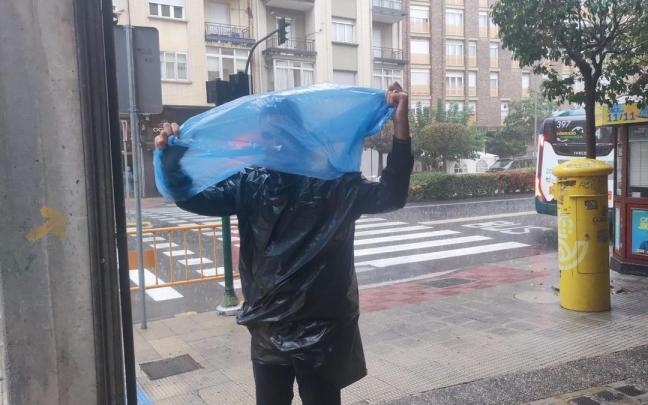 Un hombre improvisa un chubasquero con un plástico