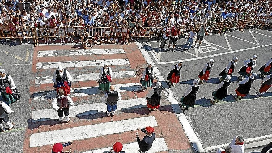 Los dantxaris delante del público asistente escuchan el redoble del tambor de los gaiteros antes del cohete.