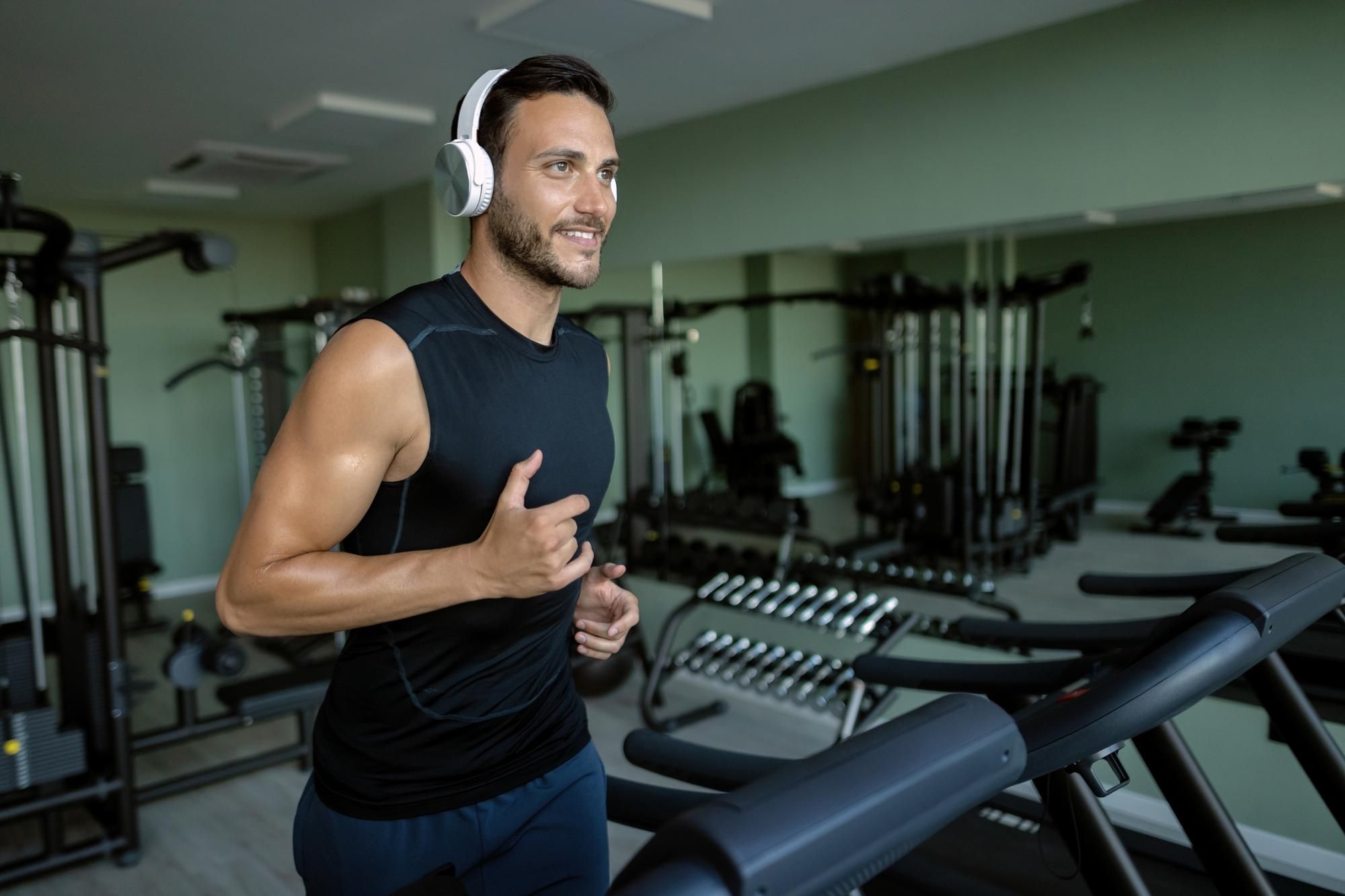 Un hombre corre en una cinta escuchando música.