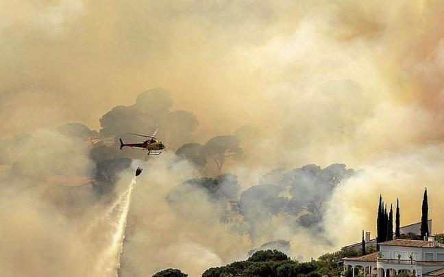 Un helic&oacute;ptero trata de sofocar un incendio forestal en Catalunya. | FOTO: EFE